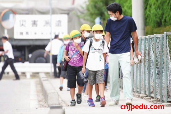 一群小学生在&ldquo;学童拥护员&rdquo;的带领下走过繁忙路段。